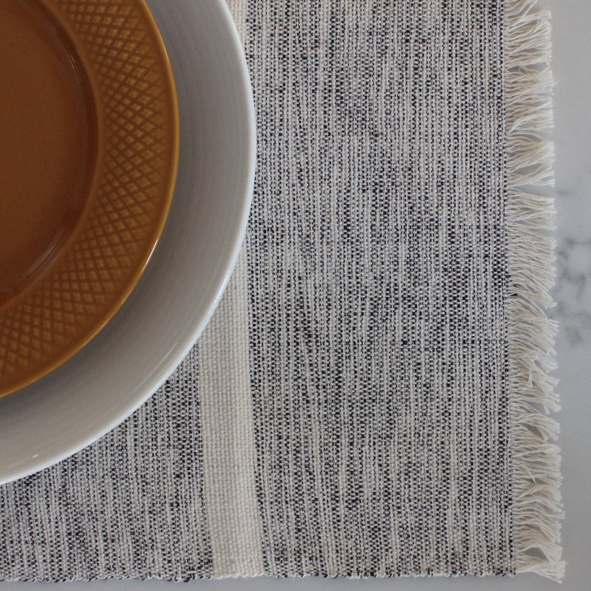 INDI mixed grey and natural striped placemats woven by hand with 100% ecologically dyed cotton by Living Threads Co.