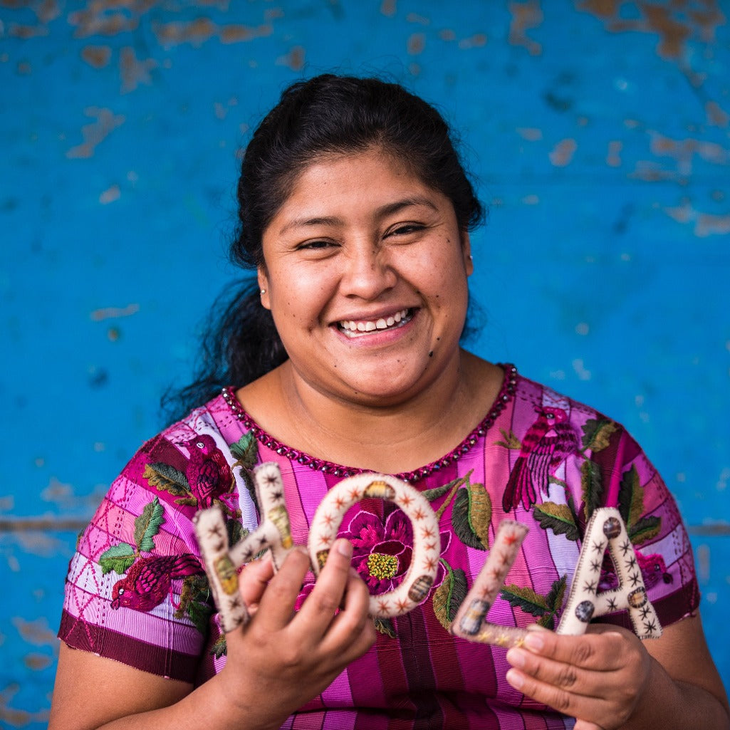 Living Threads Co. partner artisan in Guatemala with hand-stitched alphabet set.
