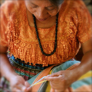 Living Threads Co artisan finishes handwoven blanket with hand spun fringe on natural dye handmade blanket