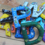 Hand-stitched and embroidered alphabet letters by Living Threads Co. artisans.