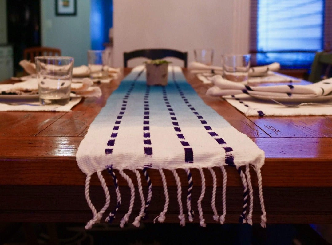 Living Threads Co. table runner in naturally dyed cotton. This blue table runner is made by partner artisans in Guatemala who use traditional techniques of dying and weaving to create unique pieces for the home. 