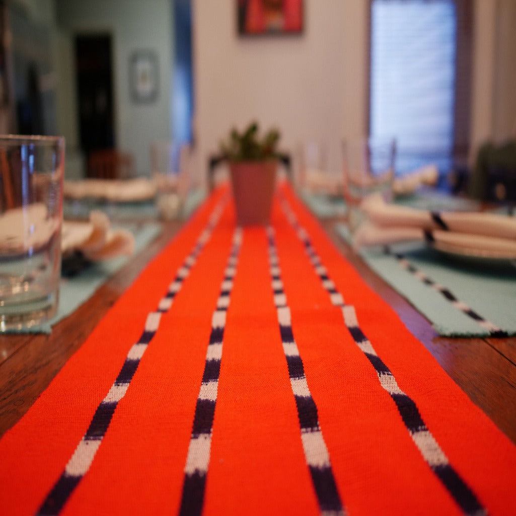 TIPICA naturally dyed bright orange Achiote cotton table runner inspired by traditional Guatemalan Ikat designs made by Living Threads Co. partner artisans.
